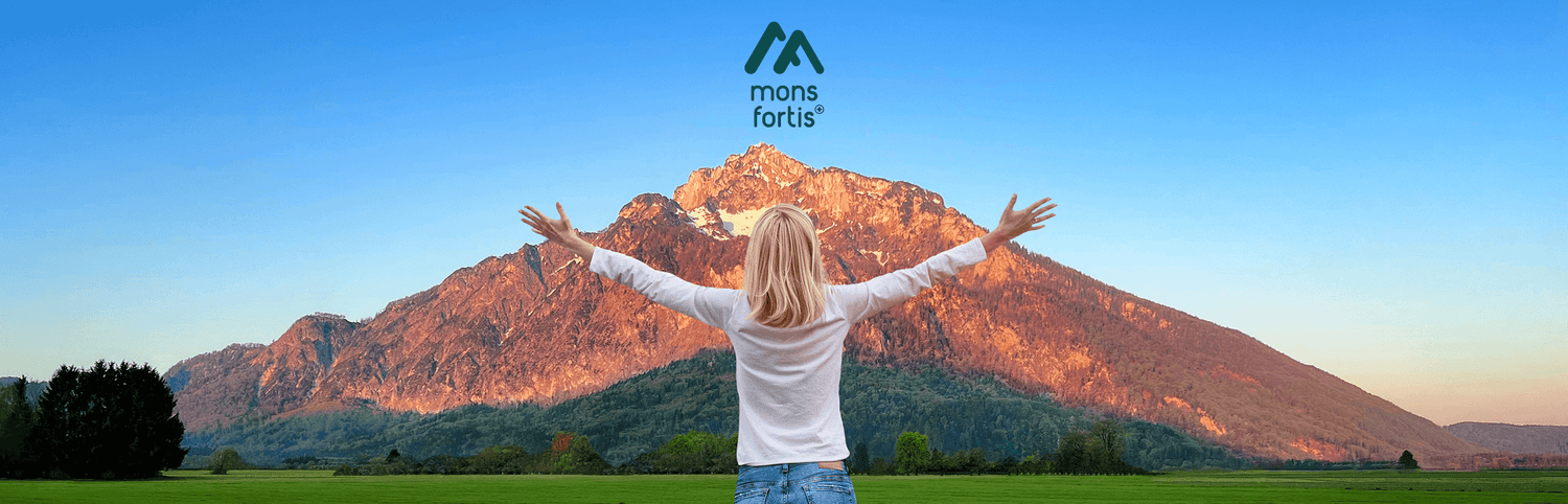 Hintergrundbild der Hauptseite, Vollbild. Frau steht vor Berg und breitet Arme aus. Über dem Berg schwebt das mons fortis Logo.